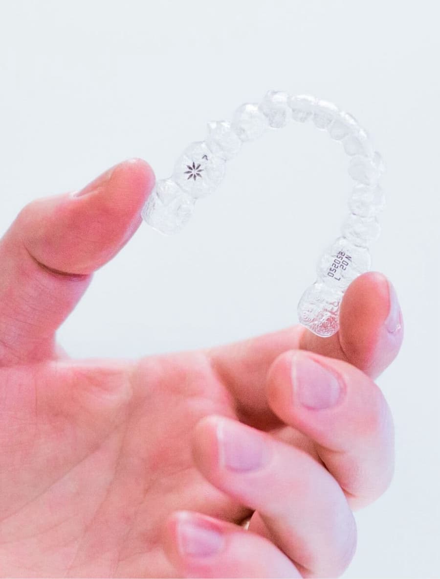 hand holding invisalign aligners